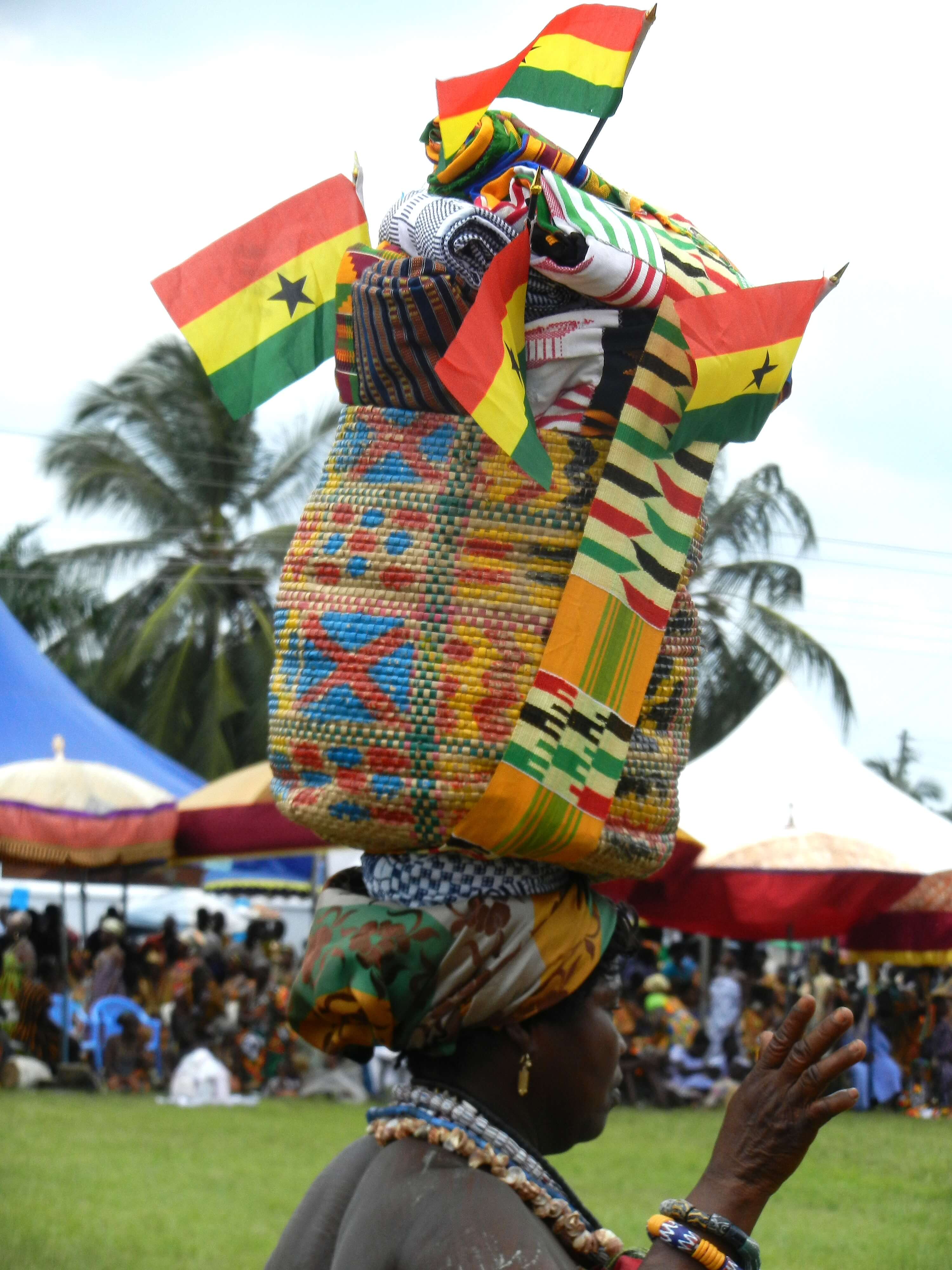 A woman carrying a kente-woven basket, decorated with Ghanaian flags, in Adaklu Kodzobi